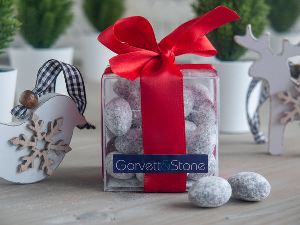 Christmas spiced almonds packaged in a clear square box tied with ribbon
