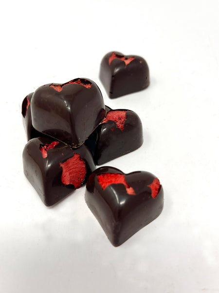 6 dark chocolate hearts with bright red freeze-dried strawberries. Loose on a white background