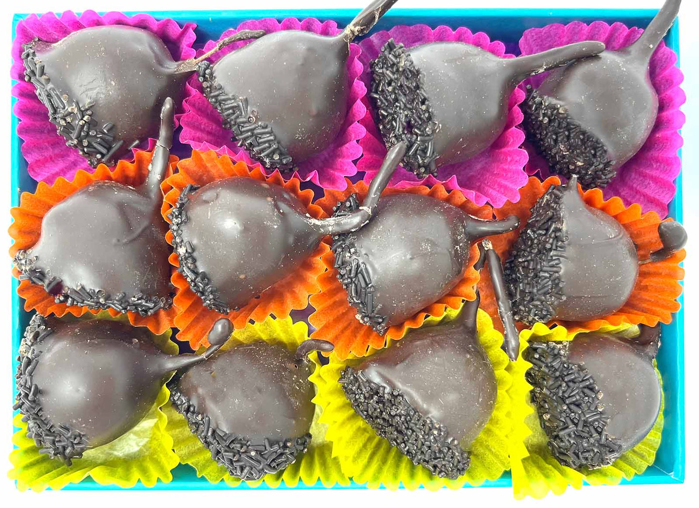 Open chocolate box with 12 dark chocolate cherry liqueurs. Each chocolate sits in a colourful paper case. Viewed from above.
