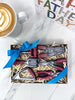 Gift set of dark chocolate miniature garden  tools in a box on a marble surface with a coffee cup and 'Fathers Day' card.