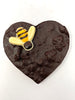 Dark Chocolate Heart with honeycomb decorated with a dark and white chocolate bumble bee. View from above on a white background.
