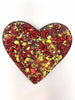 Dark Chocolate Heart decorated with scattered freeze-dried raspberries and crushed pistachios. On a white background.