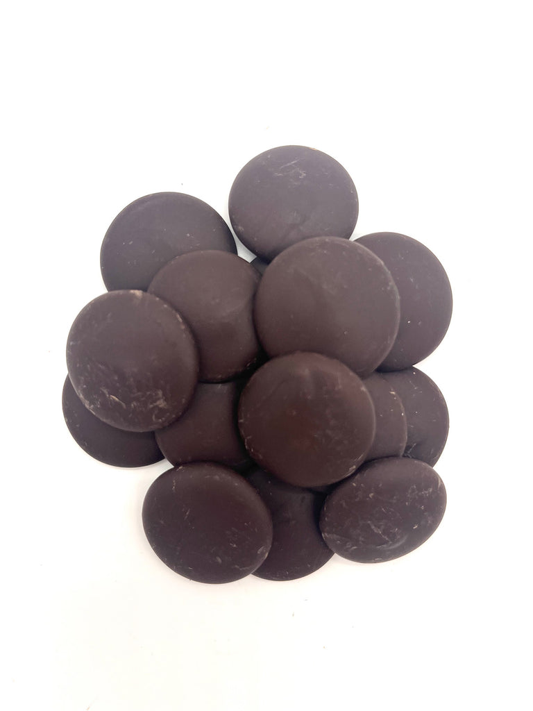 Pile of dark chocolate buttons on a white background.