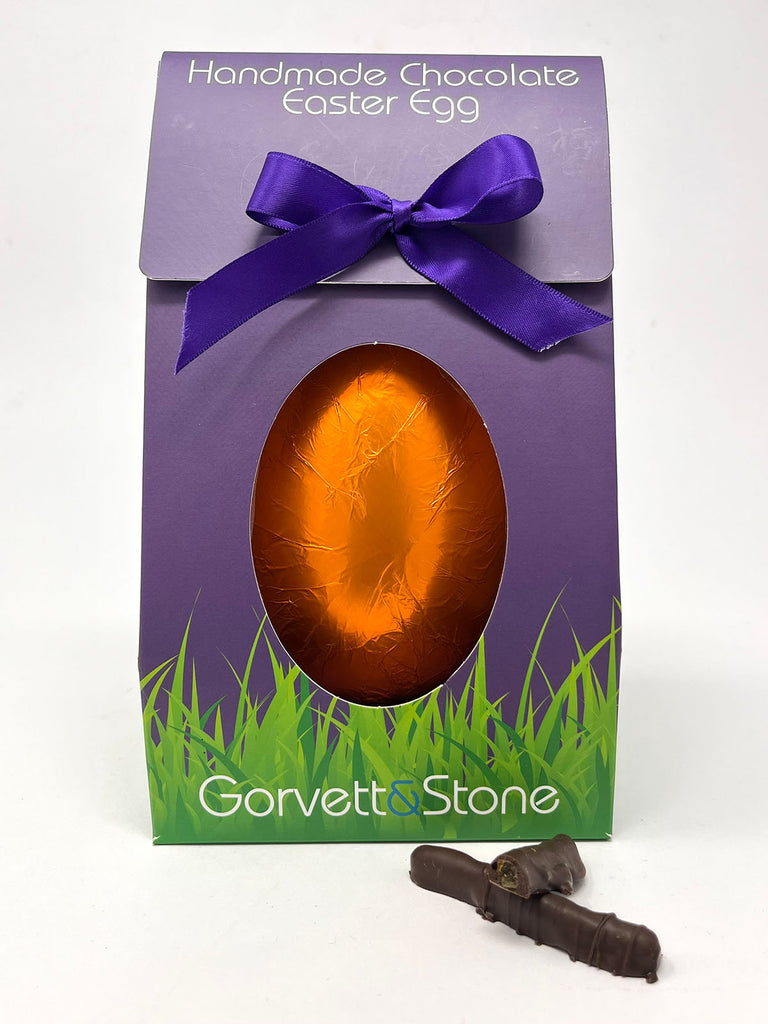 Handmade 70% dark chocolate orange Easter egg in a purple box with a purple ribbon, featuring the brand 'Gorvett & Stone'.