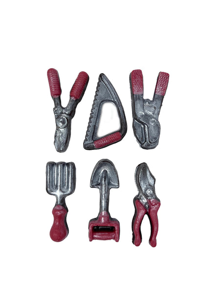 Set of miniature dark chocolate gardening tools with red handles on a white background.