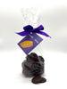 Dark chocolate buttons in a clear bag tied with a ribbon and a tag.  On a white background.