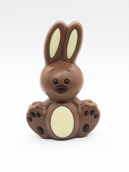 Milk chocolate bunny with white accents on a white background