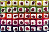 Open gift box of 40 Eton Mess chocolates in white chocolate and topped with a red freeze-dried raspberry. Each chocolate sits in a brightly coloured petit four case. Pictured from above