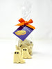 White chocolate ghosts with dark chocolate eyes, packaged in a clear cellophane bag with an orange ribbon and a 'Gorvett & Stone' brand tag.