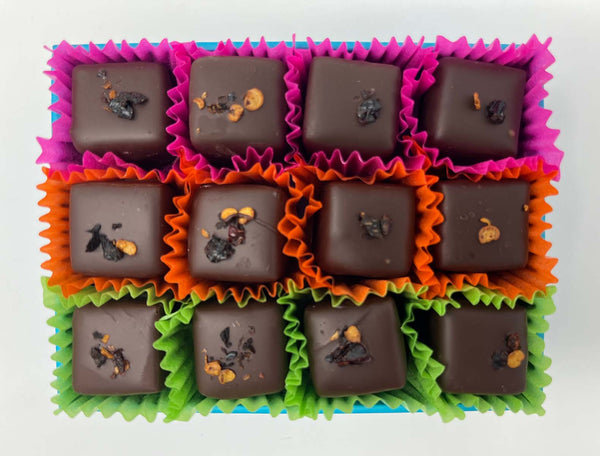 Box of 12 dark chocolates in bright coloured paper cases on a white background.