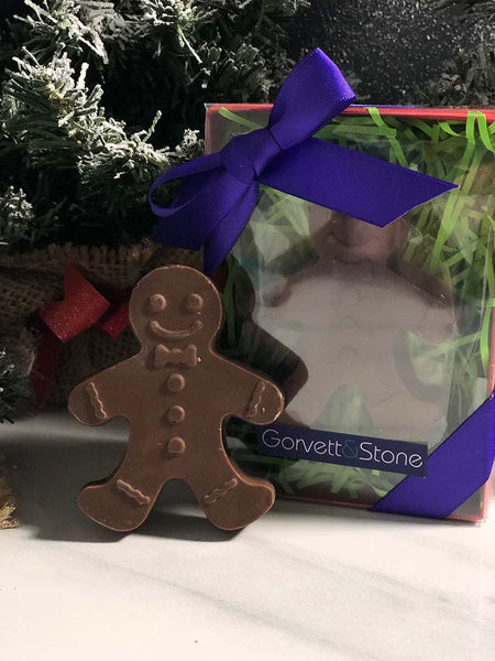 chocolate gingerbread man against chrristmas tree background