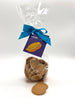 Caramelised white chocolate buttons in a clear cellophane bag tied with a G&S tag and a blue ribbon.  On a white background.