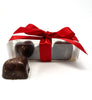 Clear box of 3 hot honey heart chocolates. Tied with a red bow.