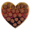 Heart-shaped box filled with chocolate truffles on a white background
