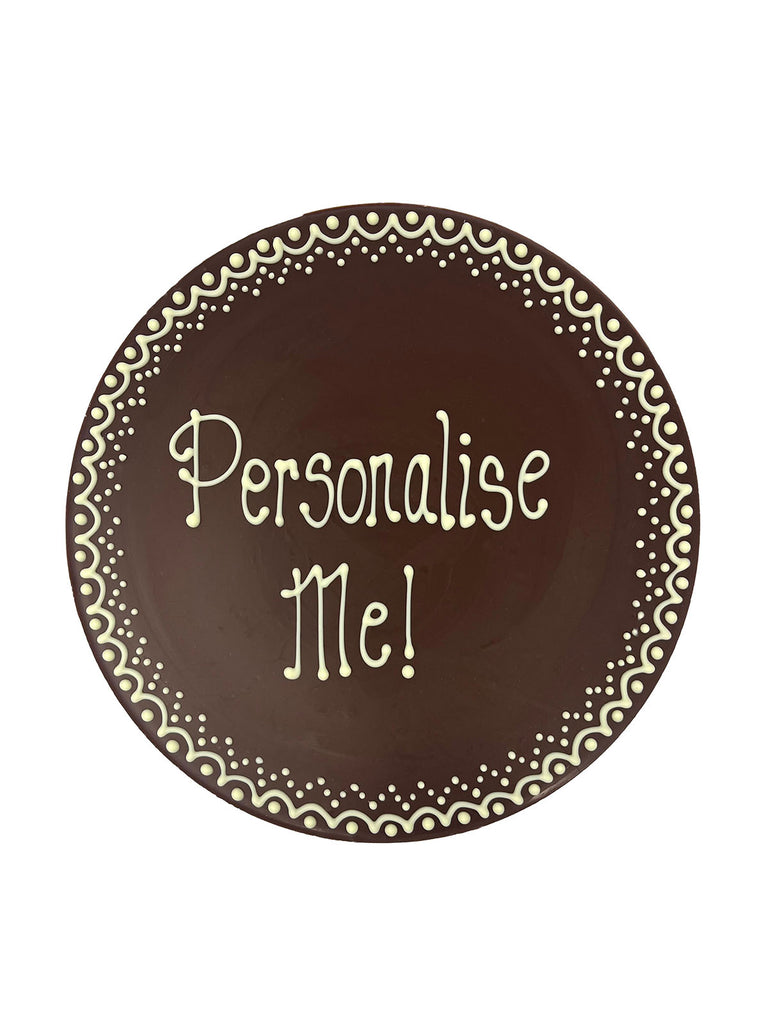 Milk chocolate plaque hand piped  with a decorative border and 'Personalise Me!' text in white chocolate. On a white background.