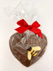 Milk Chocolate Heart with honeycomb decorated with a dark and white chocolate bumble bee. Wrapped in cellophane and tied with a red ribbon. View from above on a white background.