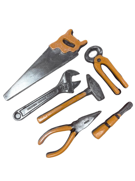 Milk chocolate tools with orange chocolate handles laid out on a white background.