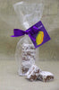 Clear bag filled with peanut butter meltaways. 2 meltaway squares placed in front of the bag. Bag is tied with a ribbon and tag on a beige cloth background.