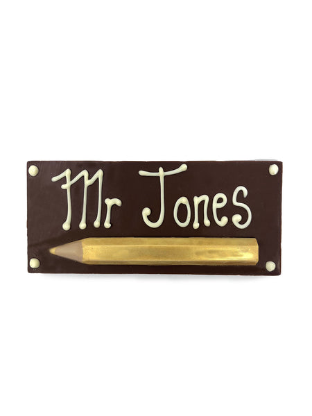 Chocolate Bar with piped decoration 'Mr Jones' and a gold chocolate pencil. On a white background.