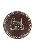 Milk chocolate plaque hand piped  with a decorative border and 'Good Luck!' text in white chocolate. On a white background.