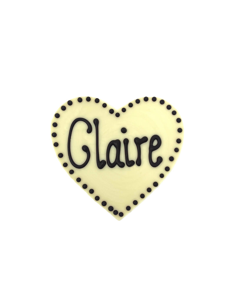 White chocolate heart piped Claire in dark chocolate. On a white background.