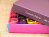 Gift box of milk and dark chocolates partially covered with the box lid to show a sneak peak.